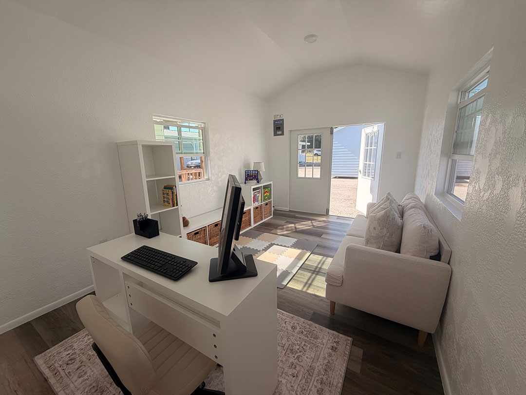 Bonus room interior — desk setup with sofa and vaulted ceiling