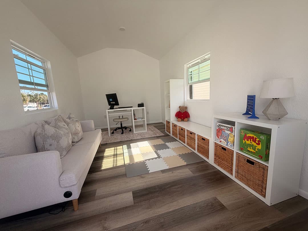 Finished interior shed — sofa, desk, and LVP flooring